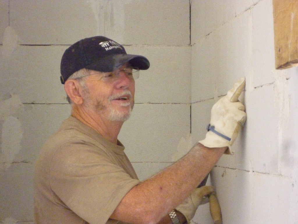 John Finnerty plastering a block wall